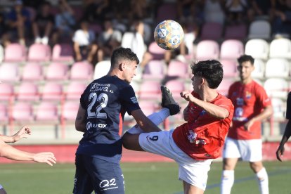 Ángel Fernández, jugador de l’Atlètic Lleida, refusa una pilota de cap davant d’Álex Sánchez.