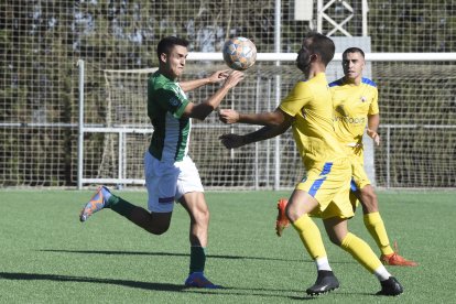 Un jugador de l’Alguaire i un del Joanenc pugnen pel control de la pilota.