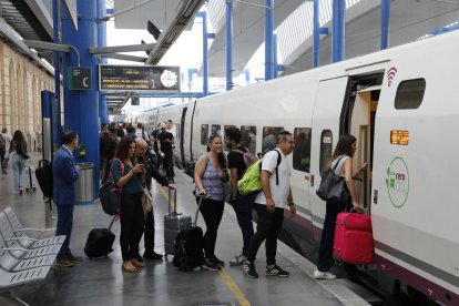 Diverses persones pujant a un tren AVE aquest divendres a l’estació de Lleida.