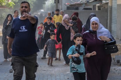 Famílies palestines fugen de les seues llars després que l’exèrcit israelià ataqués un edifici de la ciutat de Gaza.