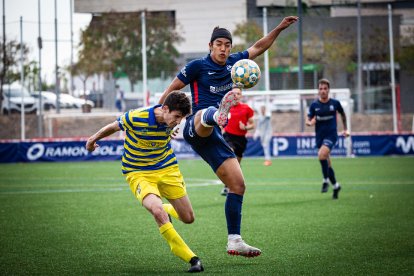 Konu intenta controlar una pilota aèria, per la qual també lluita un jugador del Palamós.