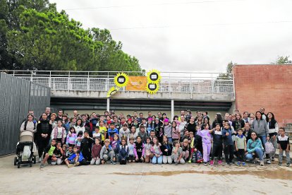 Alumnes i pares davant de la pancarta en favor de l’educació inclusiva a l’escola Joc de la Bola.