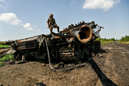 Imatge d’arxiu d’un militar ucraïnès sobre les restes d’un carro de combat rus.