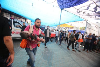 Un sanitari trasllada un nen ferit en l’atac israelià a l’hospital Al-Shifa divendres.