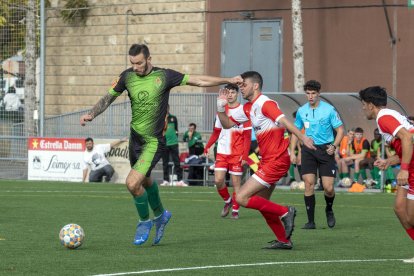 Un jugador del Cervera es disposa a rematar davant l’oposició d’un rival, a qui pica a la cara.