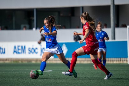 Mariajo protegeix una pilota a l’interior de l’àrea visitant davant de la pressió de les futbolistes d’Osasuna.