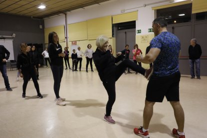 Una veïna practica amb l’instructor del taller un dels moviments apresos ahir.