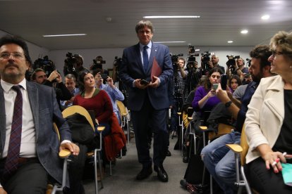 Puigdemont es dirigeix a explicar l’acord davant dels líders del seu partit, com Isidre Gavín. A la dreta, Cerdán entra a la sala on l’esperen els periodistes.