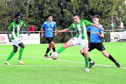 El jugador de l’Alguaire Pau Ros controla una pilota davant d’un defensor del Borges Blanques.