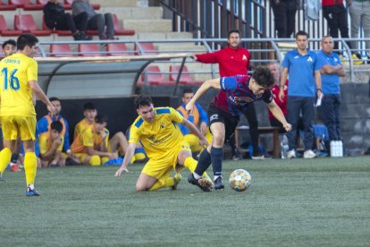 Un jugador del Tàrrega prova d’eludir l’entrada d’un rival.