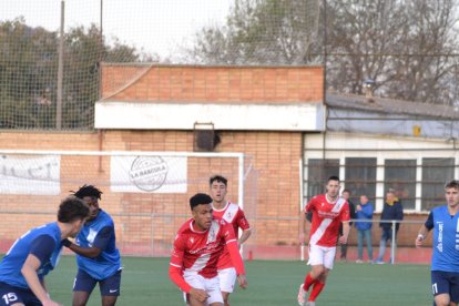 Un jugador de l’Artesa de Segre condueix la pilota davant la vigilància de dos adversaris.