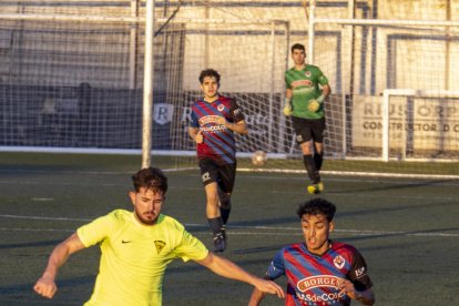 Un jugador del San Juan porta la pilota davant d’un defensa local.