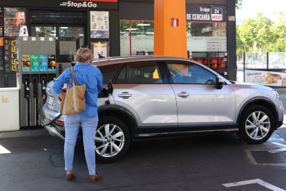 Una conductora omple el dipòsit del seu vehicle en plena operació sortida.