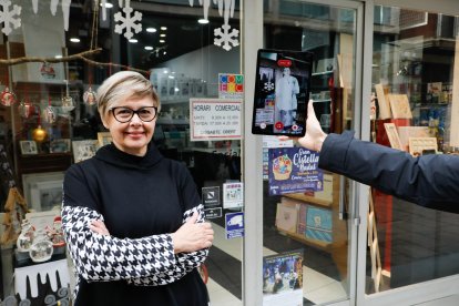 A l’esquerra, una comerciant que participa en la campanya al costat del seu holograma virtual. A la dreta, Indíbil explica la seua història i la de la ciutat a través de l’aplicació.