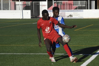 Un jugador de l’Alpicat B mira de controlar la pilota davant la pressió d’un rival.