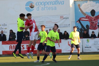 Un jugador de l’Artesa pugna amb un rival per una pilota aèria.