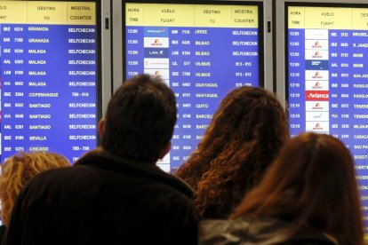 Foto d’arxiu de viatgers davant d’un plafó informatiu a Barajas.