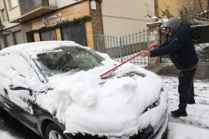 Un veí d’Esterri d’Àneu, retirant ahir la neu acumulada durant la nit al seu vehicle.