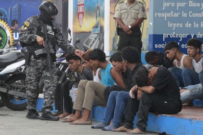 Un policia custodia membres d’un grup armat a Guayaquil.