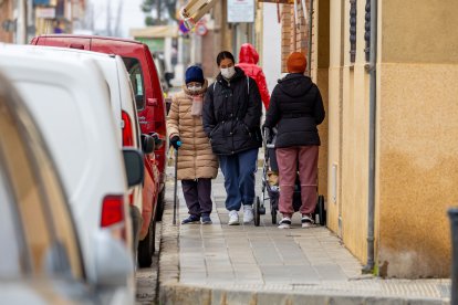 Una dona amb cotxet de nadó passa al costat d’una persona gran i l’acompanyant ahir al Secà.