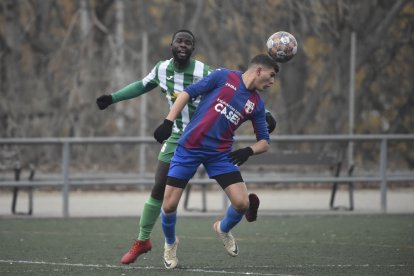 Un jugador del Torà remata de cap davant de la pressió rival.