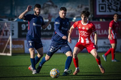 Àngel, de l’Atlètic Lleida, fa una passada davant la mirada d’un rival.