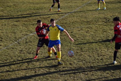 Un jugador del Pobla protegeix la pilota davant la pressió d’un rival.