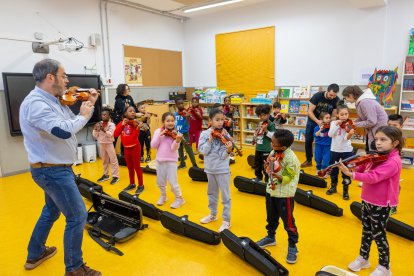 Alumnes del Magí Morera aprenent a tocar el violí.