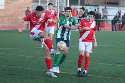 Un jugador de l’Artesa de Segre refusa una pilota davant la pressió d’un rival.