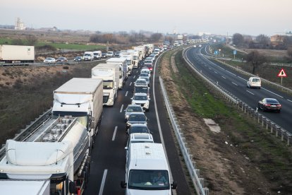 Imatge del tractor bolcat ahir a Castelldans. A la dreta, llargues cues a la tarda a l’autovia per un accident a Castellnou de Seana.