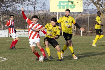 Un jugador de l’Olímpic mira de conduir la bimba davant la pressió del rival.