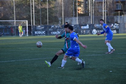 Un jugador de la Seu intenta fer una passada, pressionat per un rival de l’Oliana.