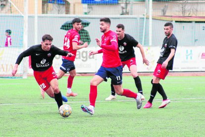 El local Mikel avança amb la pilota entre jugadors de l’Alpicat.