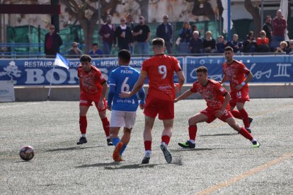 Un jugador del Rapitenca persegueix la pilota davant de la presència de futbolistes del Mollerussa.