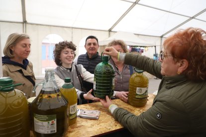 Visitants de la Fira de Vinaixa comprant una garrafa d’oli de 5 litres al recinte.