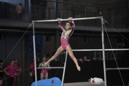 Una gimnasta fent el seu exercici a les asimètriques.