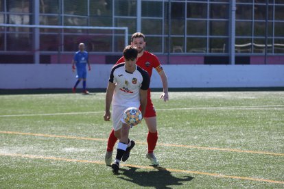 Un jugador del Borges B prova de jugar la pilota davant de la pressió del rival.