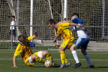 Dos jugadors del Lleida B protegeixen l’esfèric davant la pressió d’un rival.