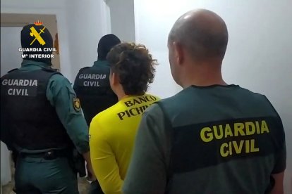 Tres agents de la Guàrdia Civil escorten un membre de la banda.