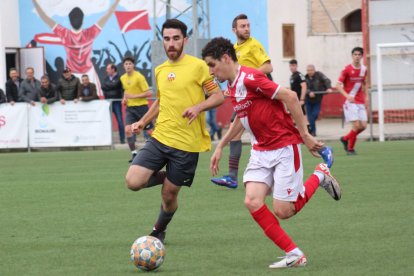 Un jugador de l’Artesa de Segre porta la pilota davant d’un defensa.