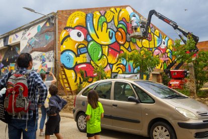 El públic va poder presenciar ahir els últims retocs als murals de Penelles.