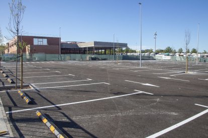 Vista del pàrquing pavimentat, les places delimitades i els nous arbres.