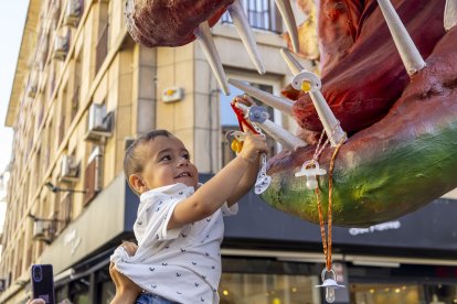 Un nen, aixecat pel seu pare, entregant el xumet a Lo Marraco.