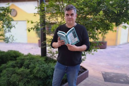 Ramon Usall sosté dos exemplars del seu últim llibre en les edicions en català i castellà.