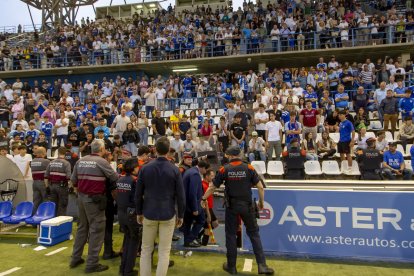 Agents dels Mossos protegeixen la retirada de l’àrbitre diumenge.