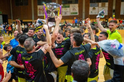 Els jugadors del Futsal Lleida celebren l’ascens de categoria amb la copa de campions.