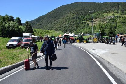 Alguns viatgers van creuar caminant amb les maletes.