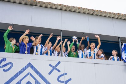 Les jugadores de l’Espanyol aixequen el trofeu de vencedores del Memorial Dani Rodrigo a la llotja del Recasens.