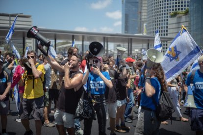 Manifestants israelians criden consignes a Tel-Aviv en una concentració pels nou mesos de guerra.