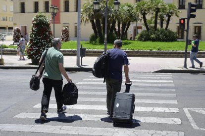 Els agents sortint de la Diputació amb el material confiscat.